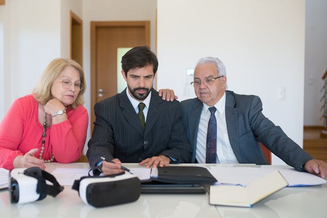 three-people-looking-at-papers-sitting-down